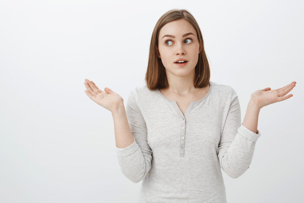 girl acting clueless front parents portrait cute emotive european female brunette shrugging with hands spread aside turning away while lying making unaware uncertain expression